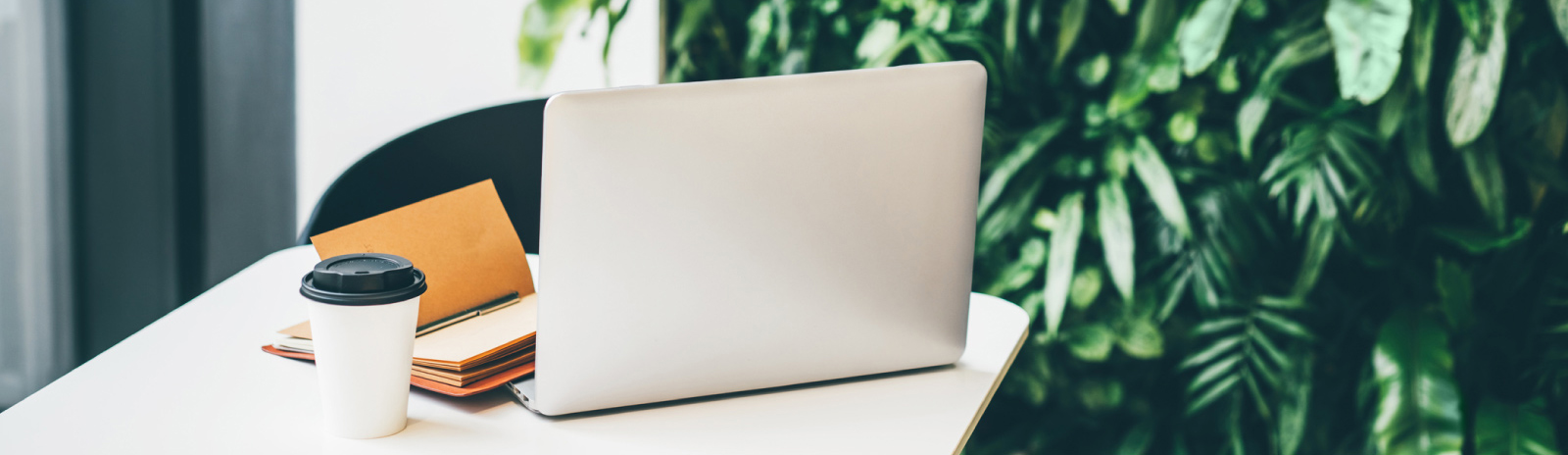 a laptop computer sitting on a table next to a cup of coffee